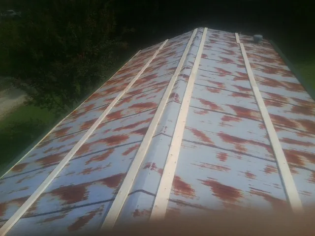 Rusted metal roof panels with new wood purlins before replacement — Storm Damage Roof Repair in Sabine Pass by Roofing Brothers