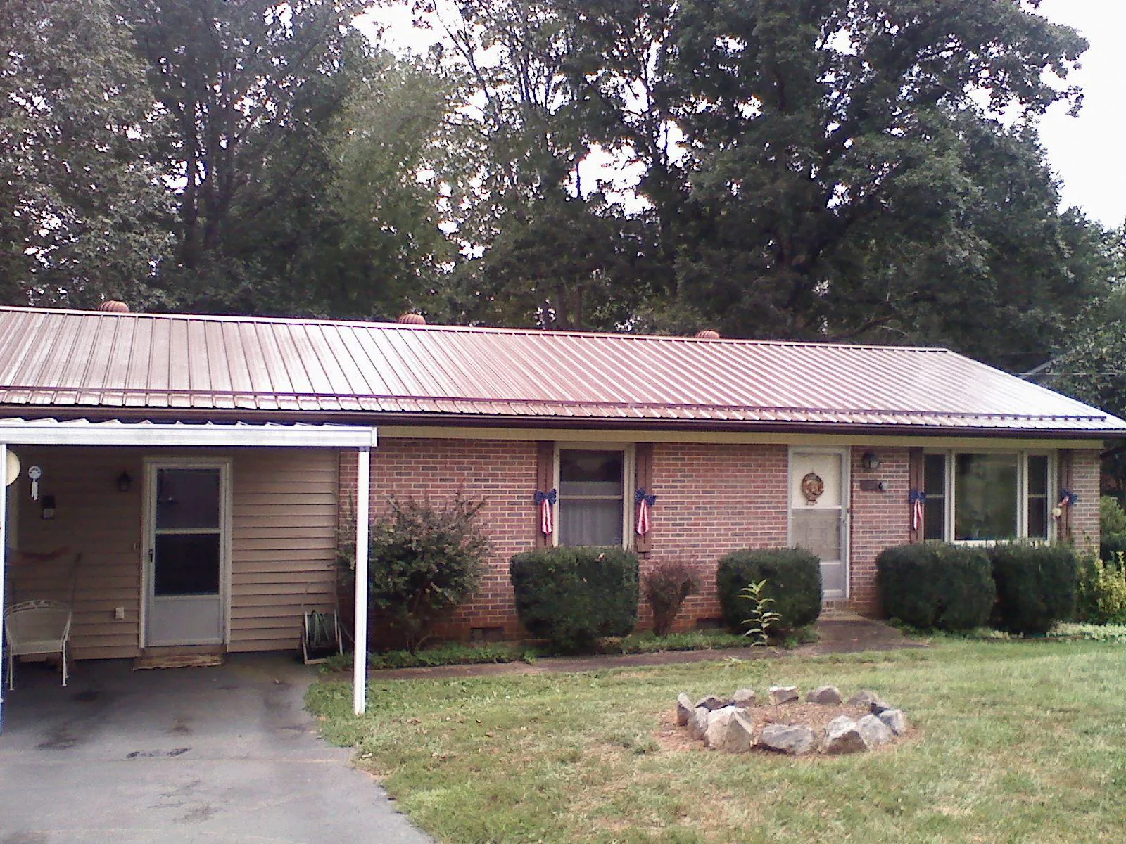 Bronze metal roof and carport on a brick ranch home — Roof Repair work by our crew in Sabine Pass