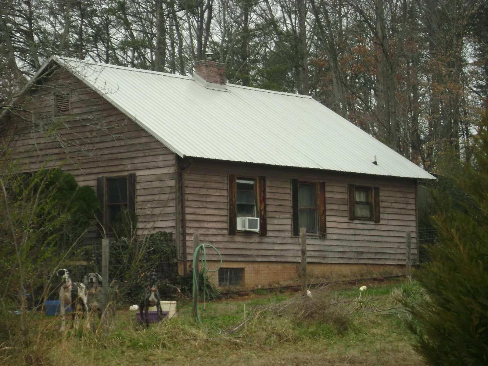 White metal roof on an old wood sided farmhouse, from a Metal Roof Installation job in Sabine Pass